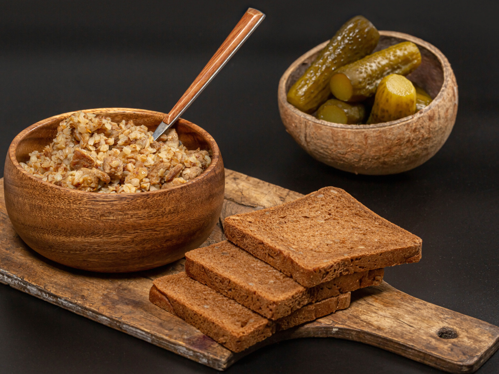 Гречка на столе с хлебом и огурцами