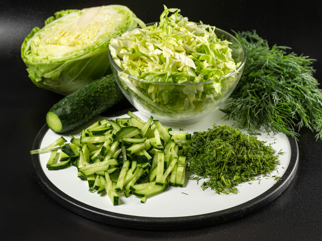 Салат с капусты на столе с огурцами и укропом 