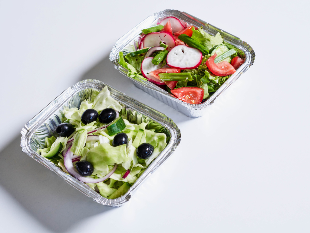 Салат из свежих овощей в тарелках на сером фоне 