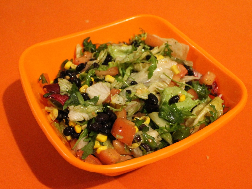 Салат из свежих овощей на оранжевом фоне