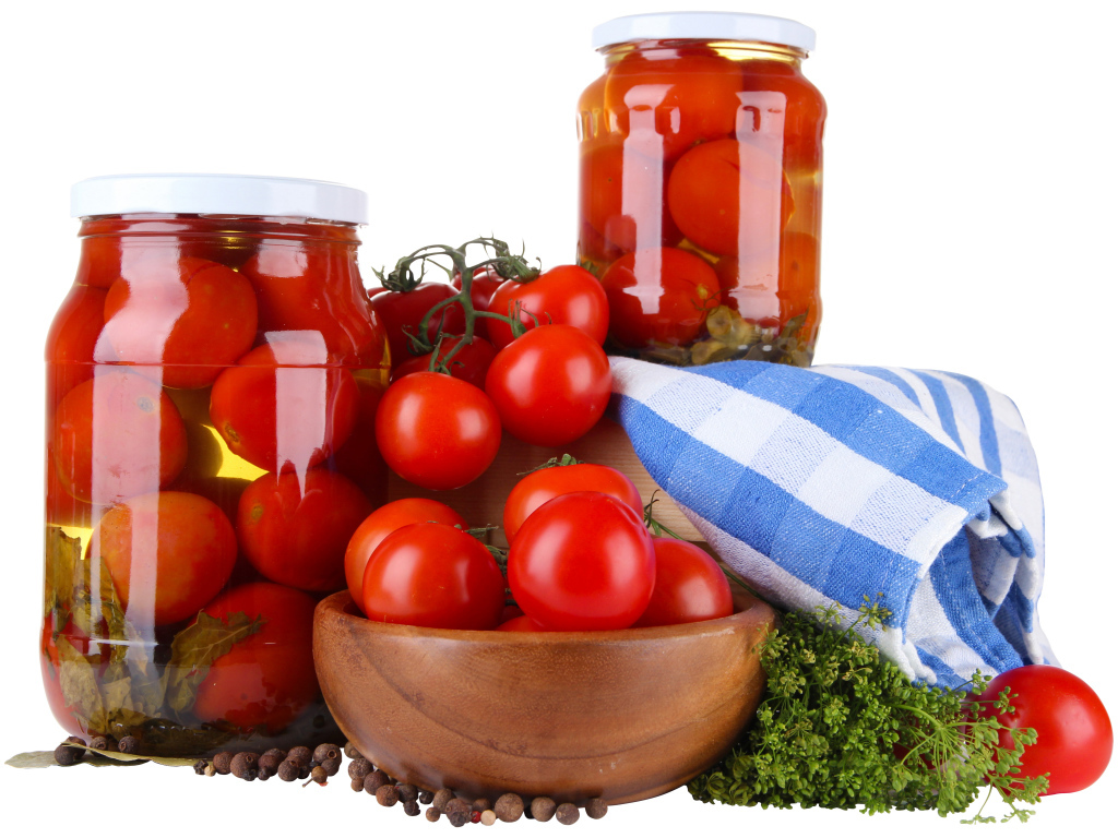 Маринованные помидоры в банках на столе со свежими