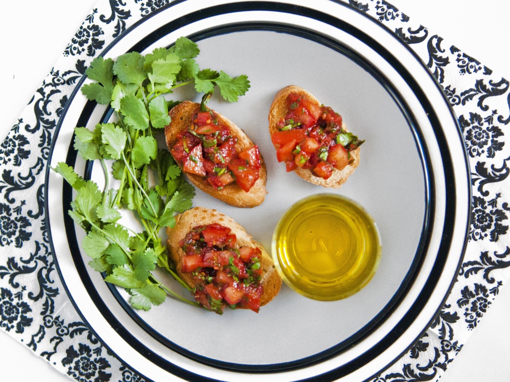 Бутерброды с помидорами на тарелке с петрушкой и маслом