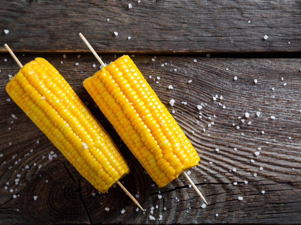 Два початка вареной кукурузы на столе 