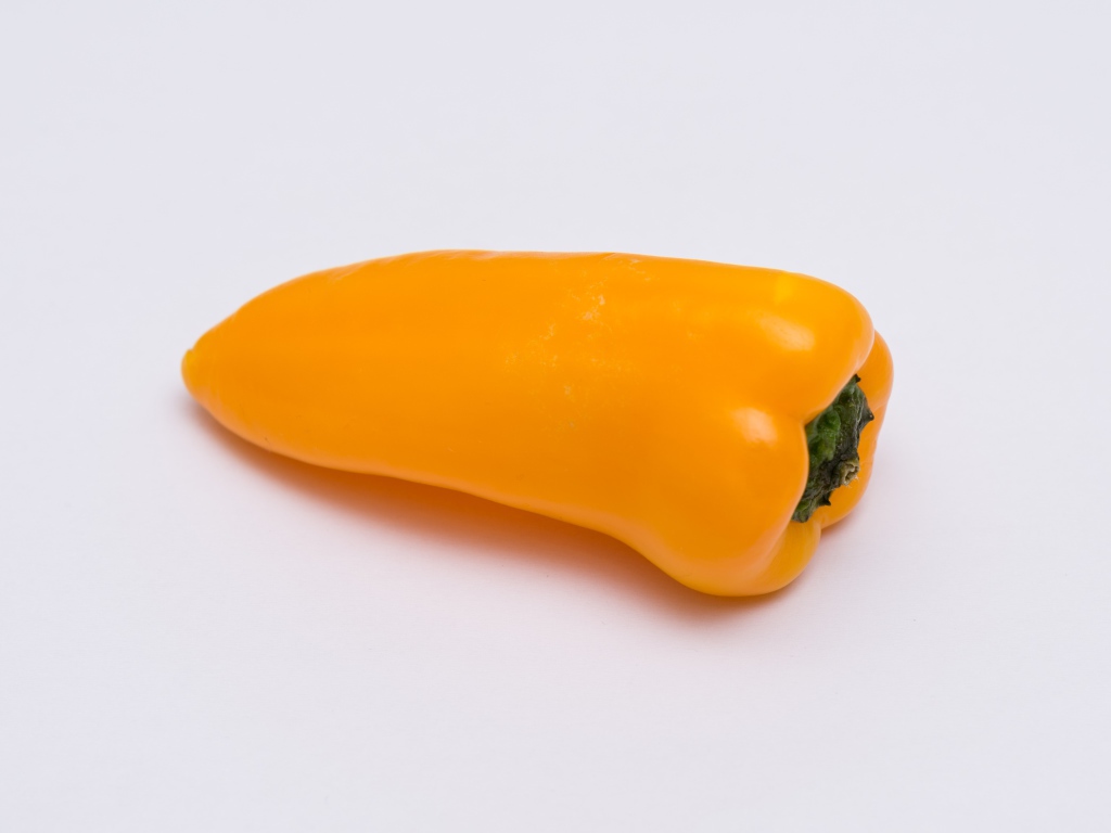 Желтый болгарский перец на сером фоне