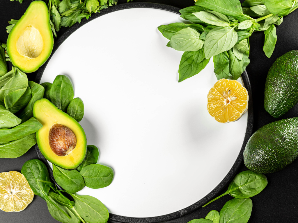 Авокадо с листьями базилика на белом фоне