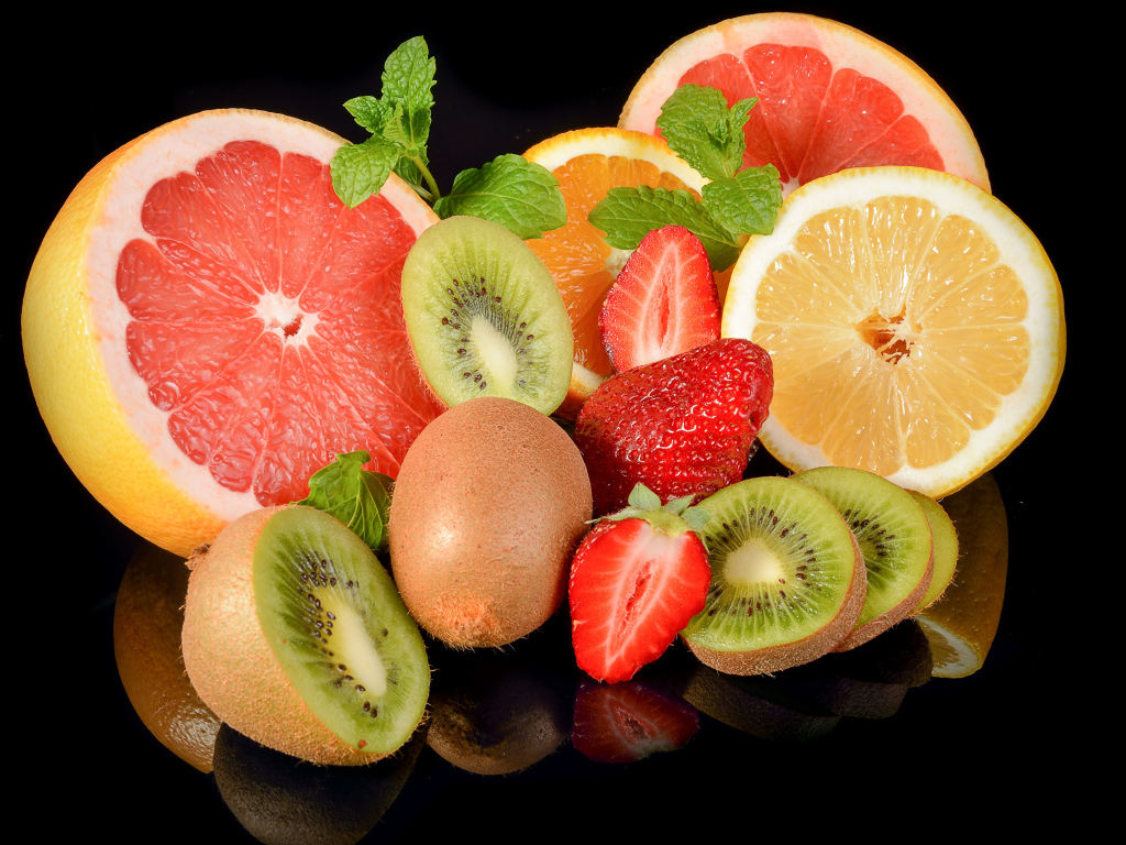 Цитрусовые фрукты с клубникой на черном фоне