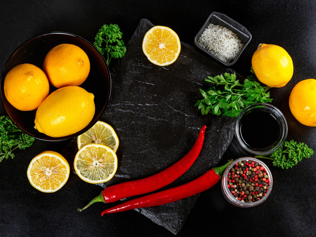 Лимоны на столе с красным перцем, петрушкой  и специями