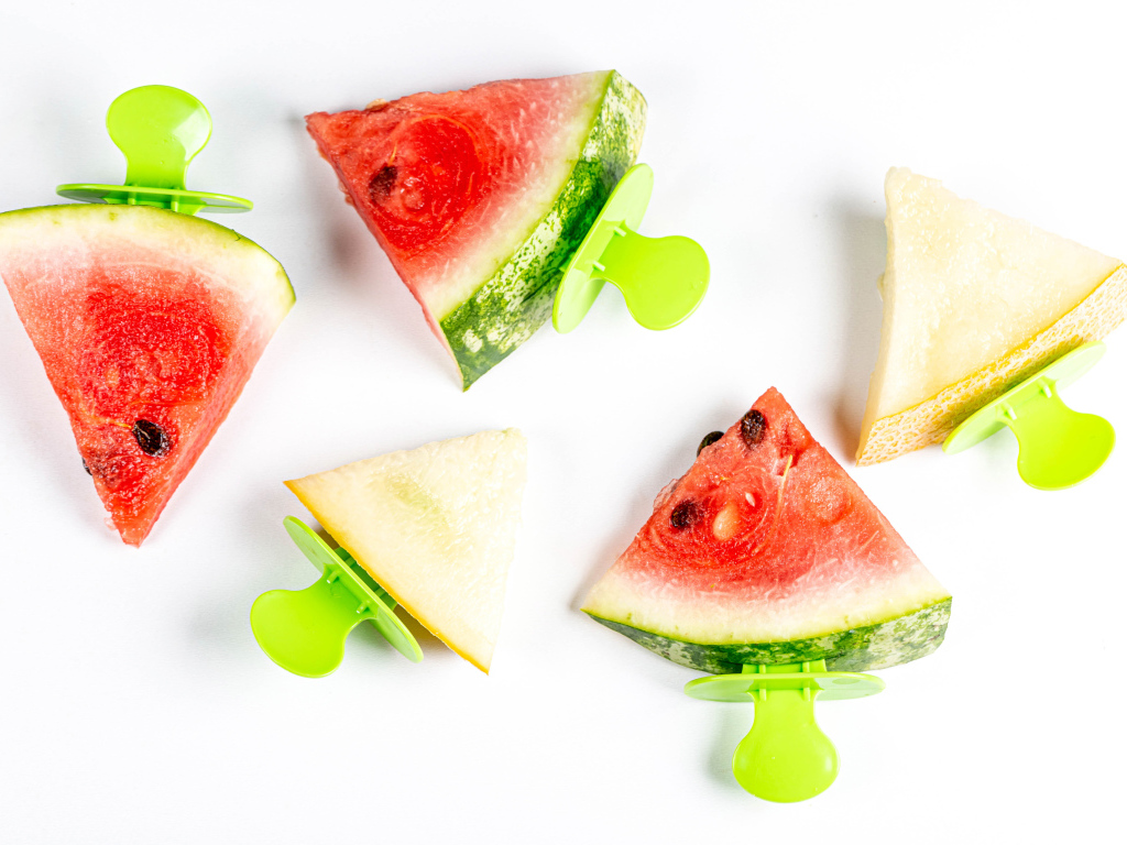 Кусочки арбуза и дыни на палочке на белом фоне 