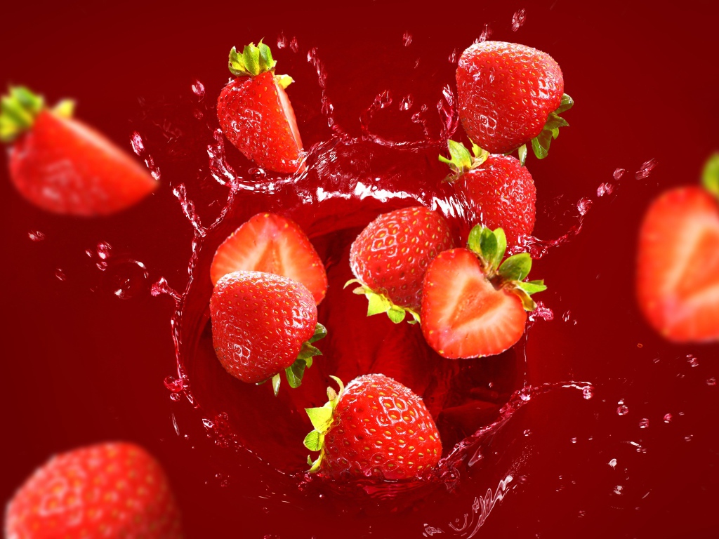 Клубника падает в воду на красном фоне 