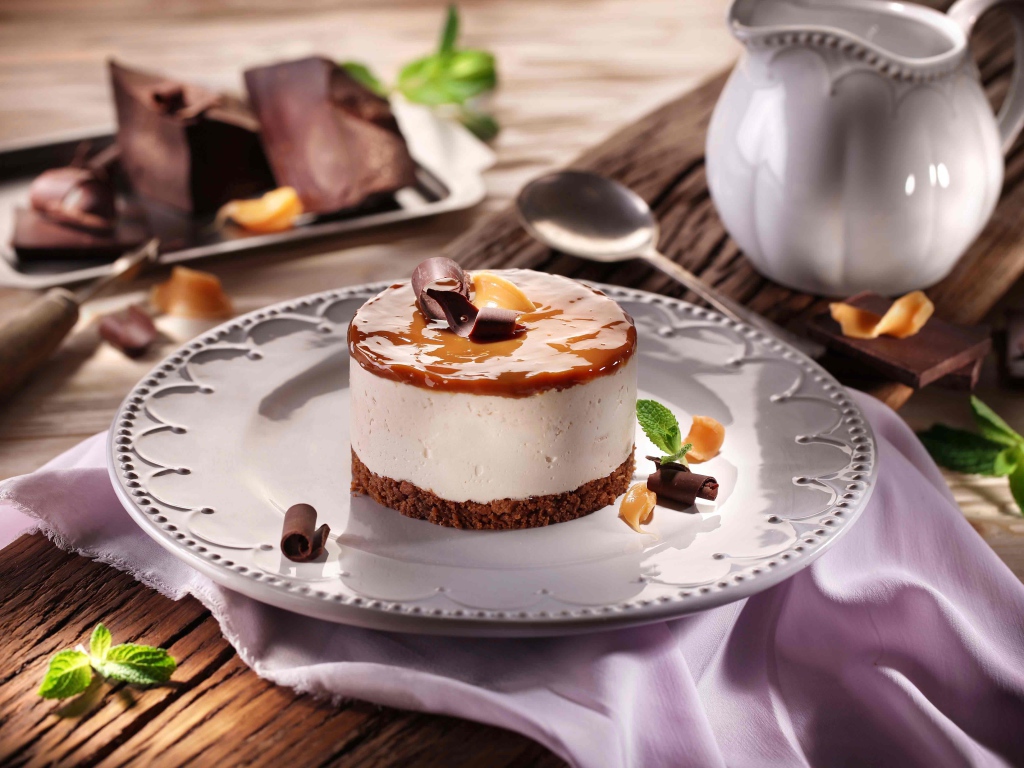 Пирожное на большой круглой тарелке на столе с шоколадом