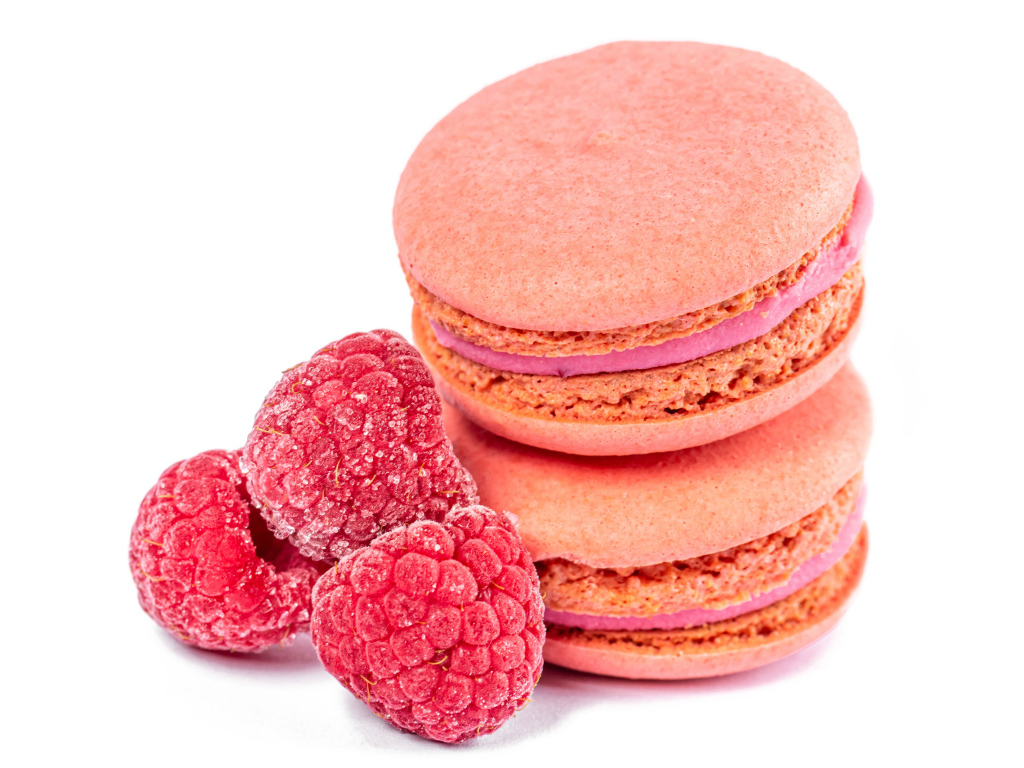 Десерт макарон с малиной на белом фоне