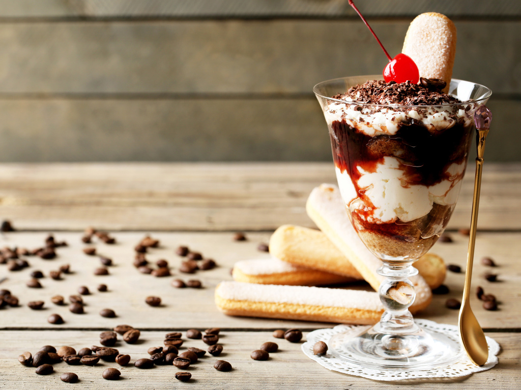 Десерт с печеньем савоярди на столе с кофейными зернами