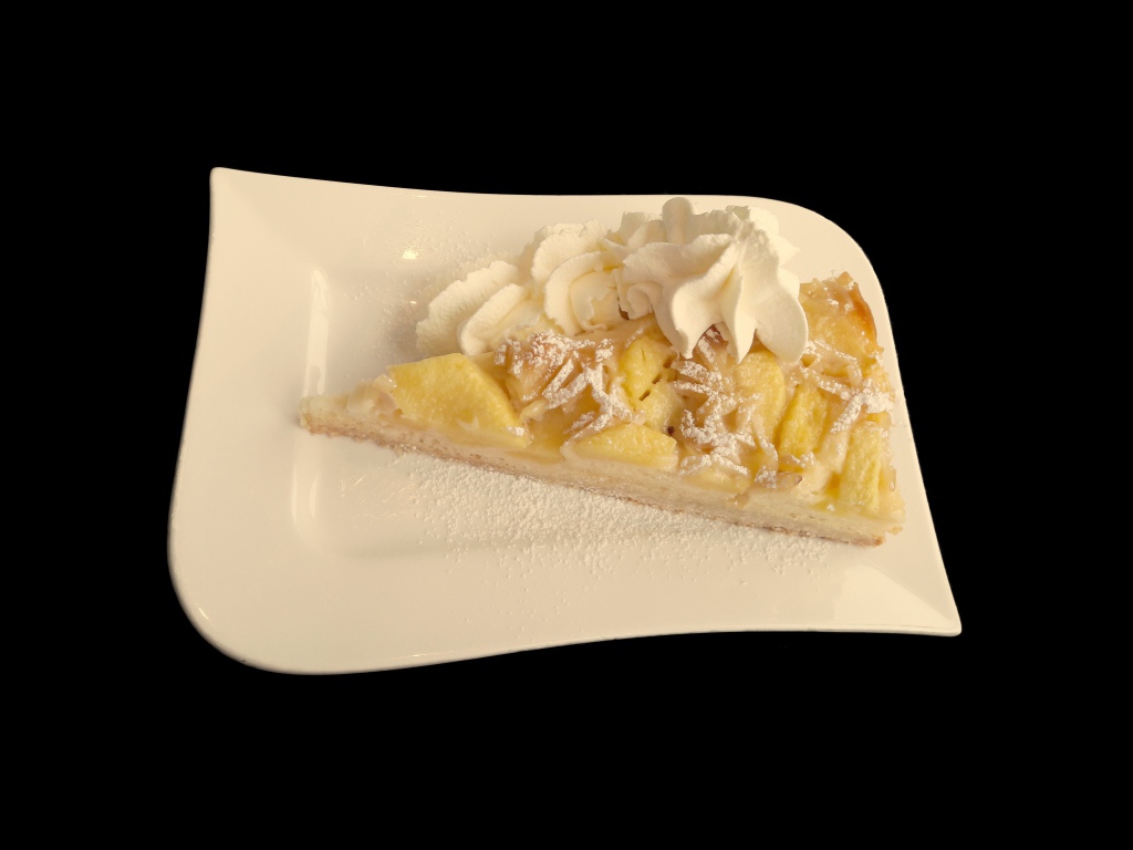 Кусок пирога с фруктами в белой тарелке на черном фоне