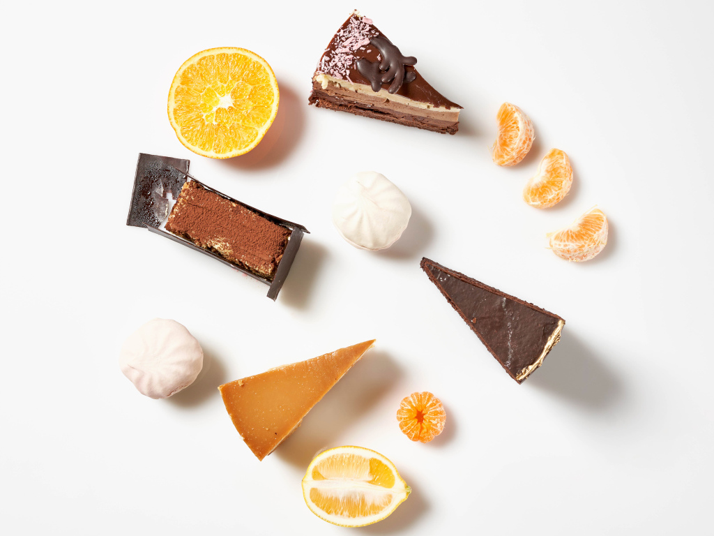 Куски торта на белом фоне с мандарином и лимоном