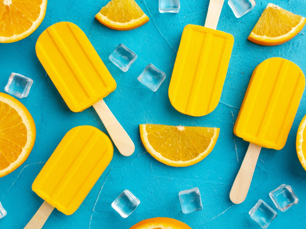 Фруктовое мороженое с кусочками льда и апельсина на голубом столе 