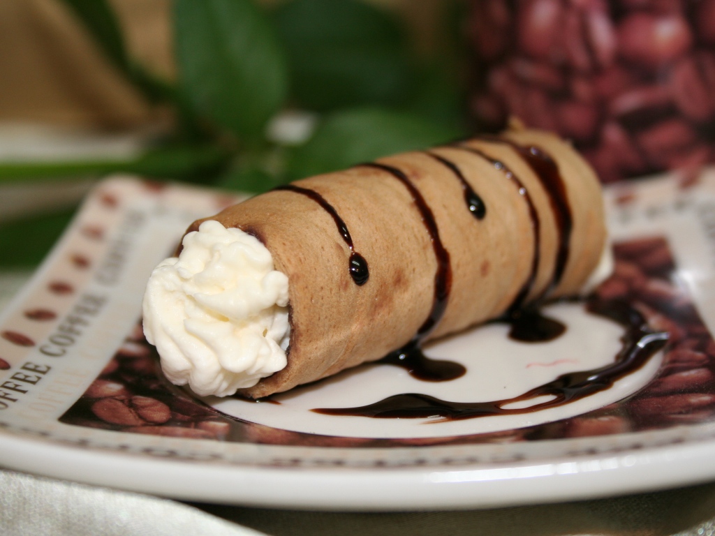 Сладкая трубочка с ванильным кремом на тарелке