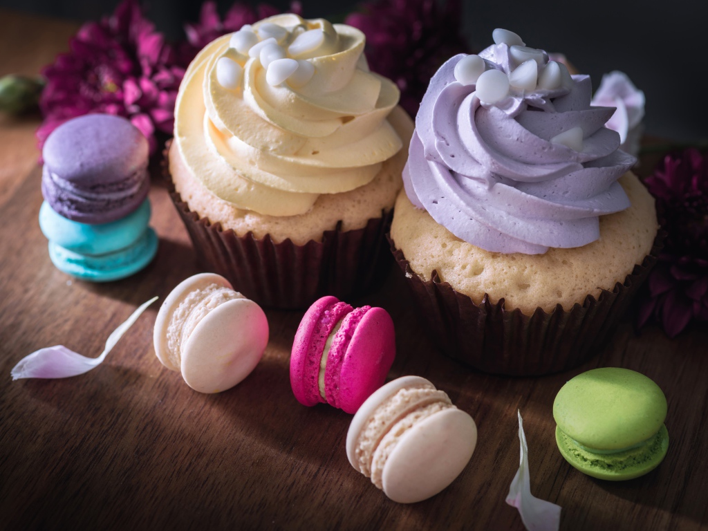 Два капкейка на столе с десертом макарун