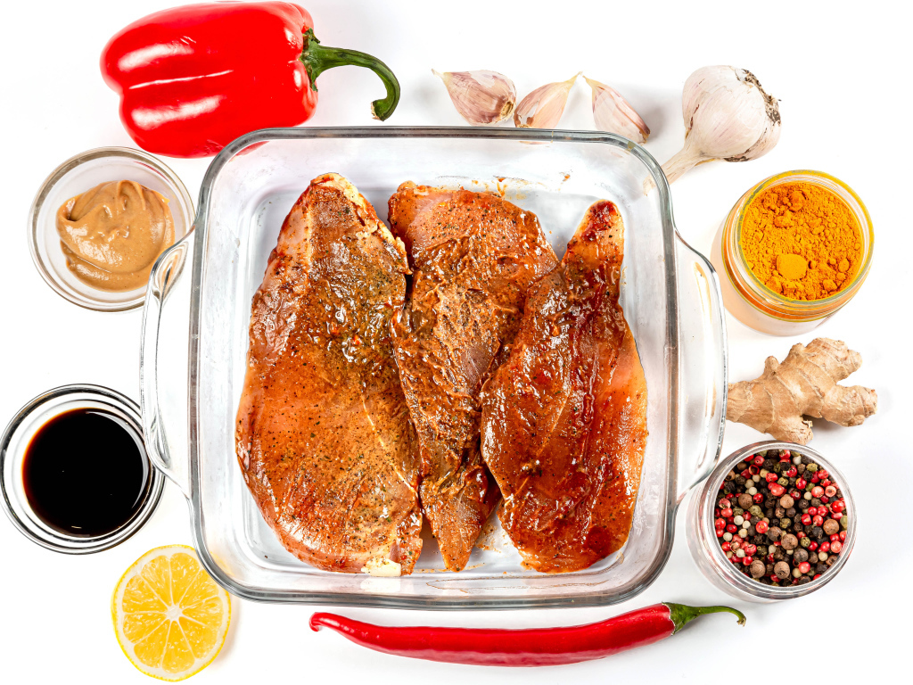 Маринованное мясо на столе со специями и соусом