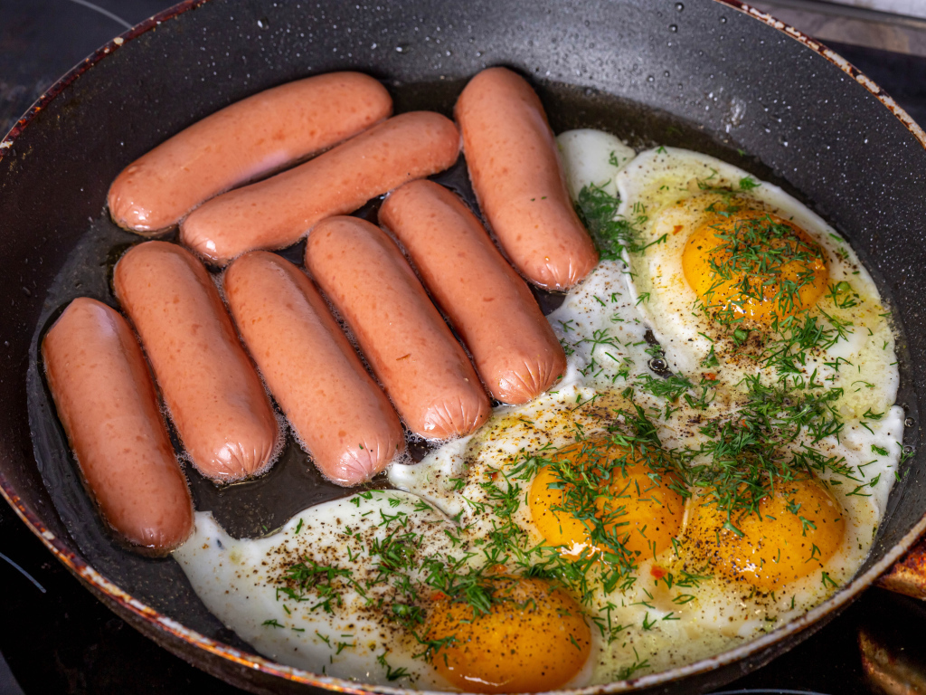 Сосиски с яичницей на сковороде