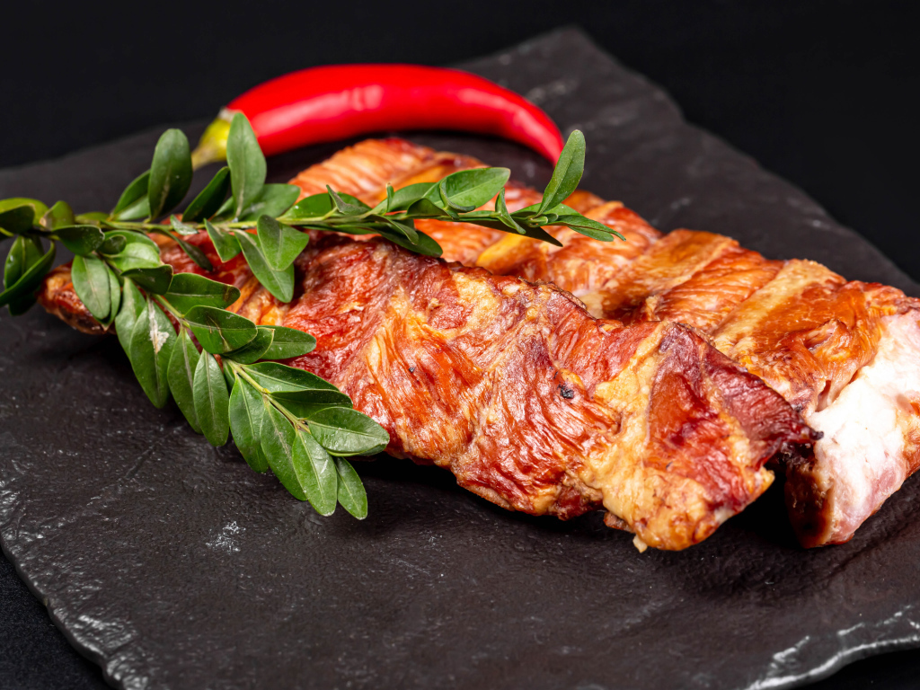 Копченые свиные ребрышки с зелеными листьями