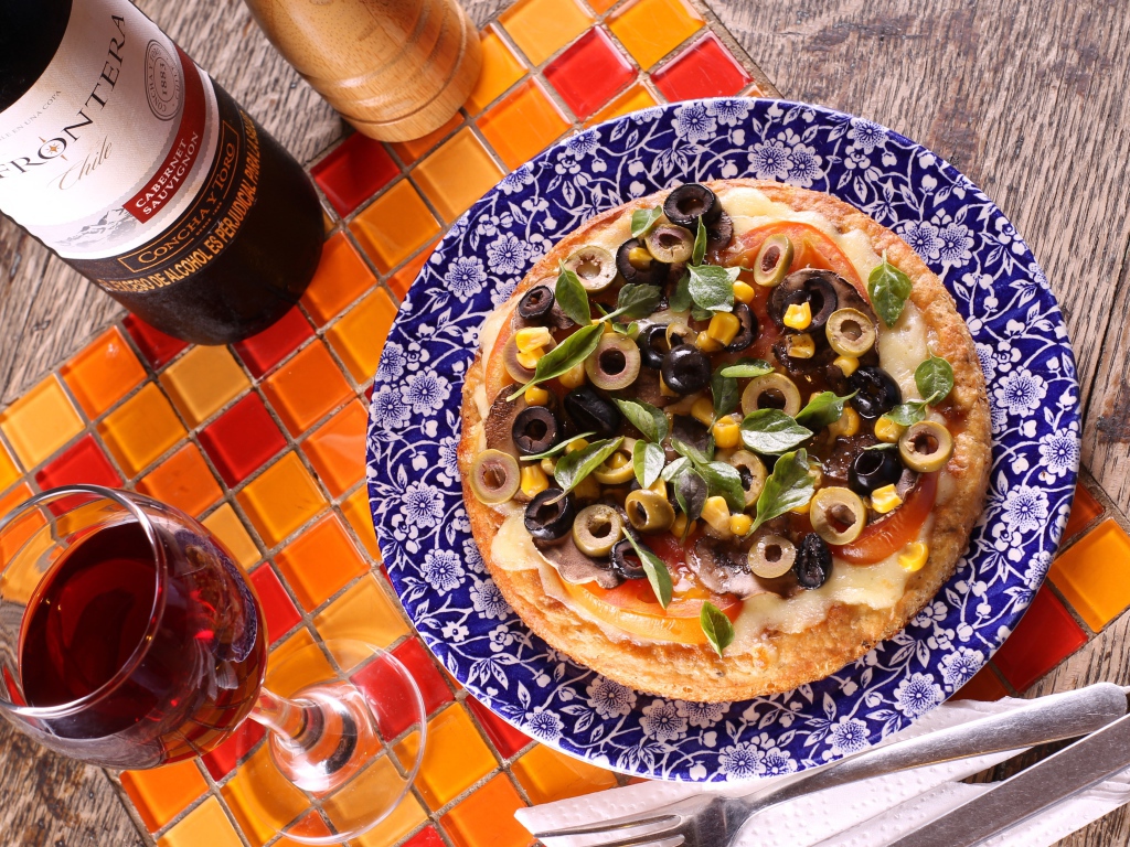 Итальянская пицца с оливками на столе с вином