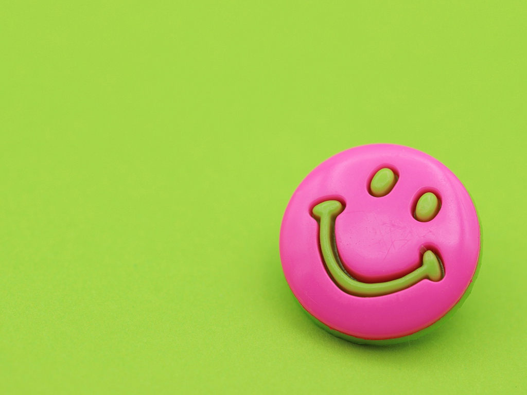 Pink smiley on green background