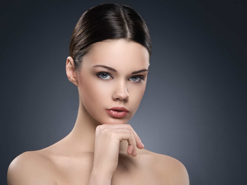 Красивая голубоглазая девушка на сером фоне 