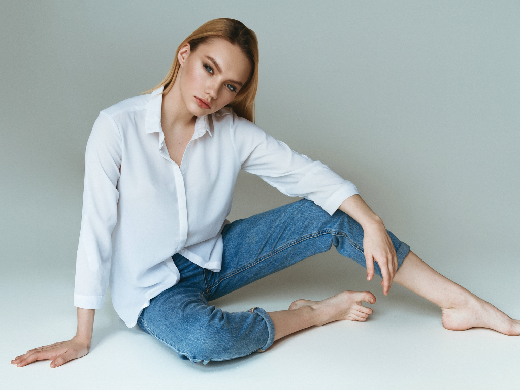 Красивая девушка в белой рубашке на сером фоне