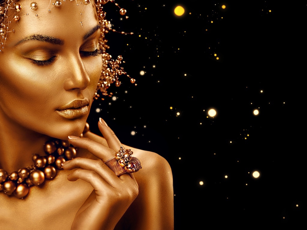 Красивая девушка в золотой краске на черном фоне