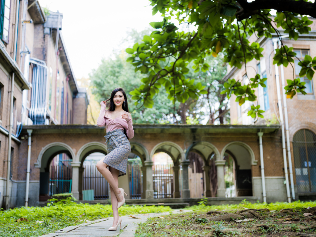 Красивая стройная азиатка на фоне здания