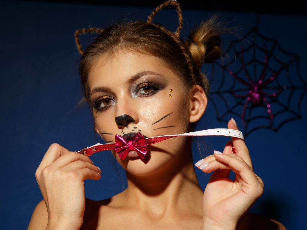 Девушка кошка с красным бантиком во рту 