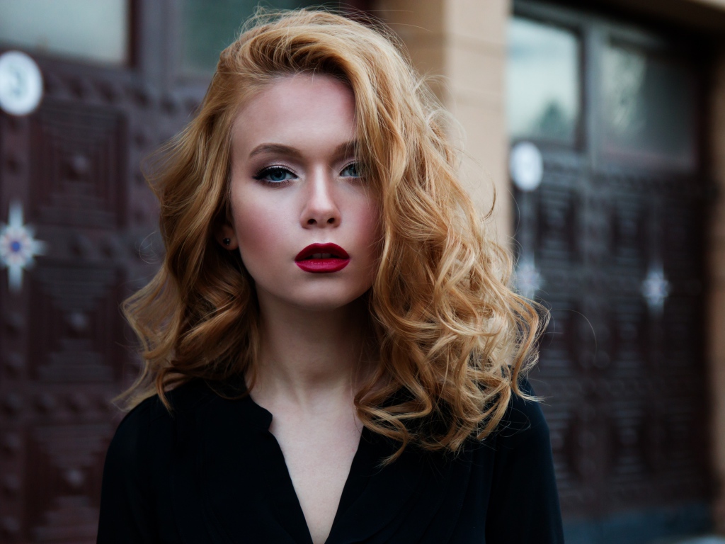 Милая блондинка с красными губами у дома