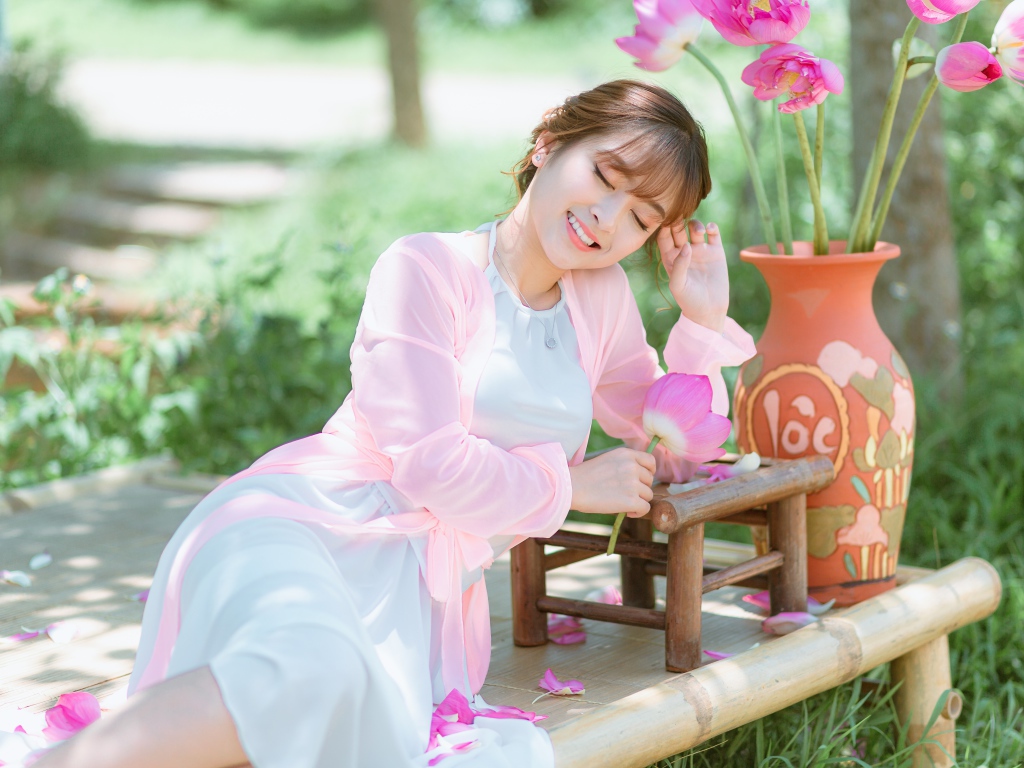 Мечтательная девушка азиатка с цветами лотоса