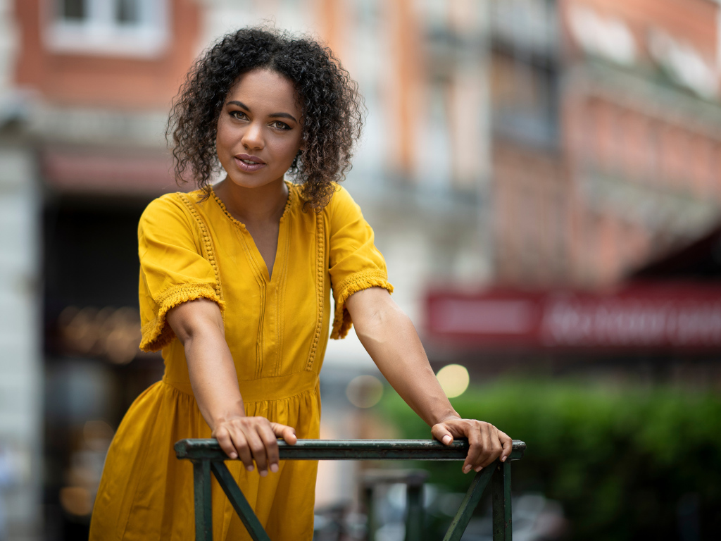 Девушка с кудрявым волосами в желтом платье