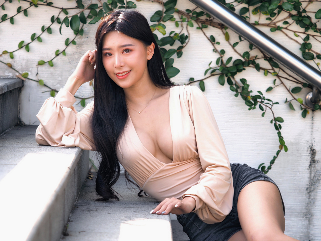 Улыбающаяся девушка азиатка с черными волосами на ступенях 