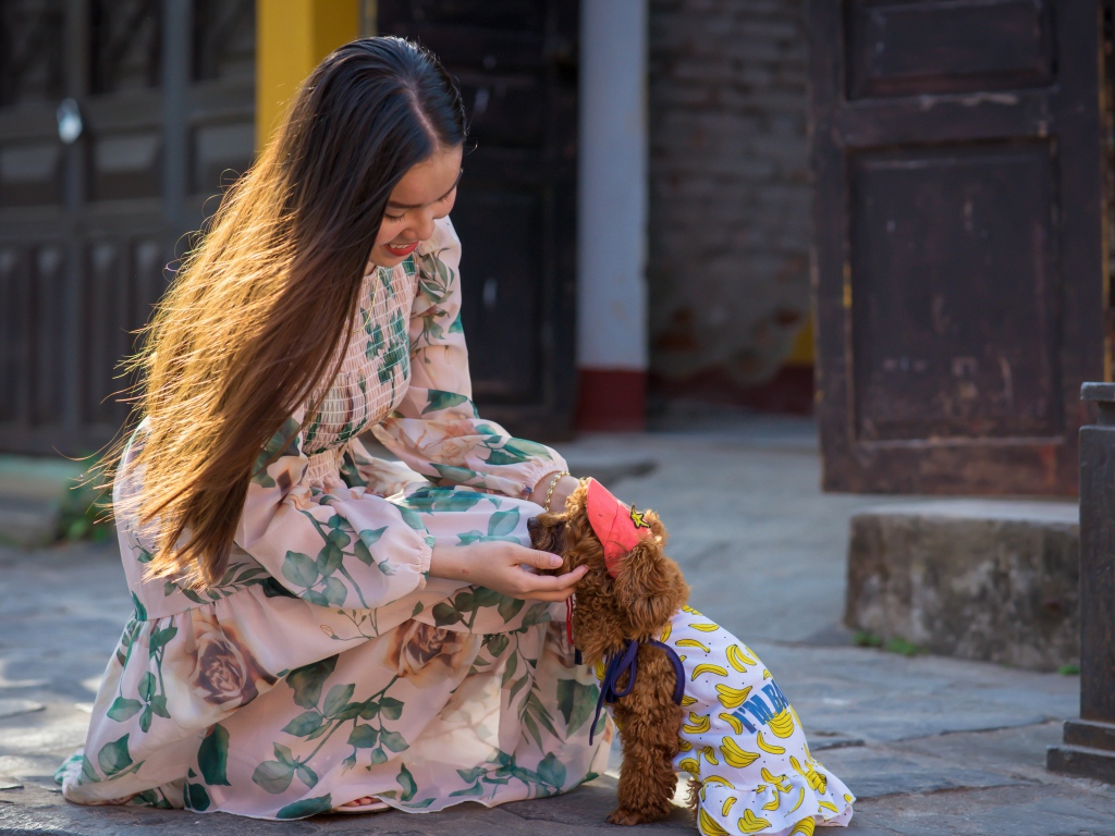 Улыбающаяся девушка азиатка с собакой 