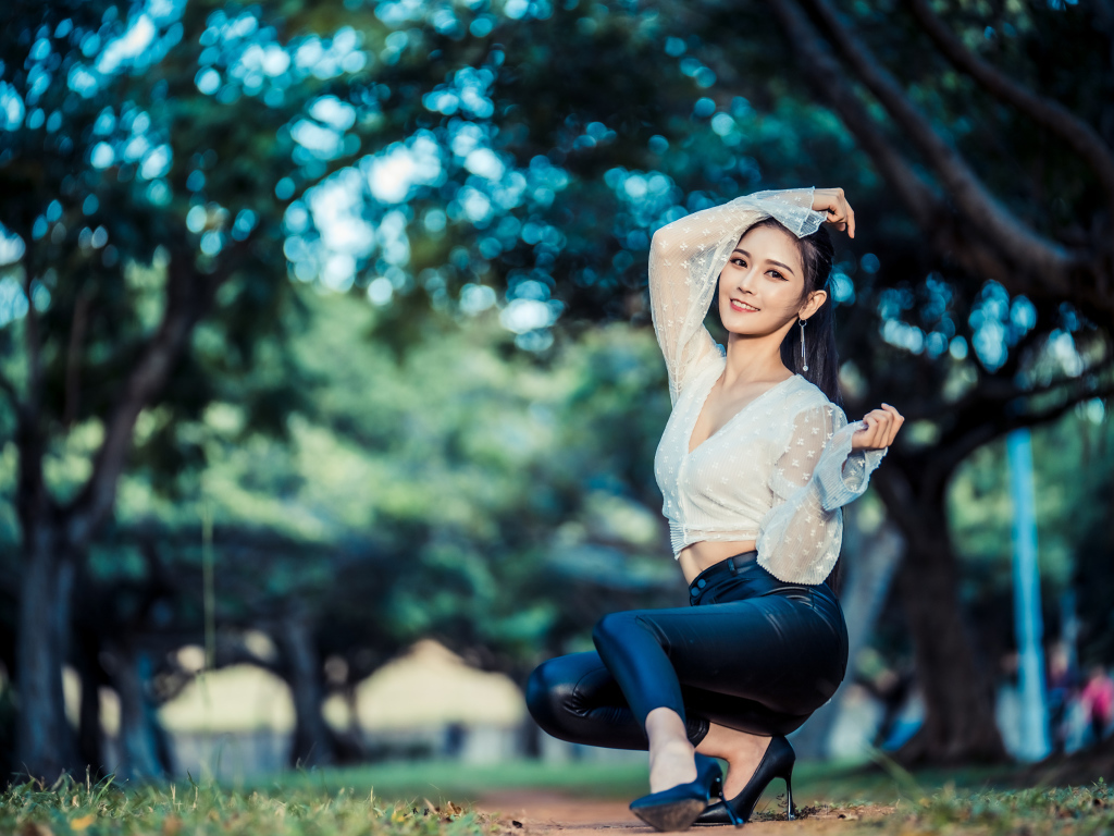 Улыбающаяся азиатка в черных брюках