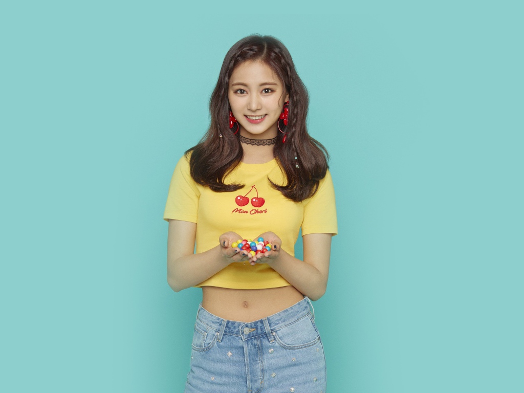 Улыбающаяся девушка с конфетами в ладонях на голубом фоне 