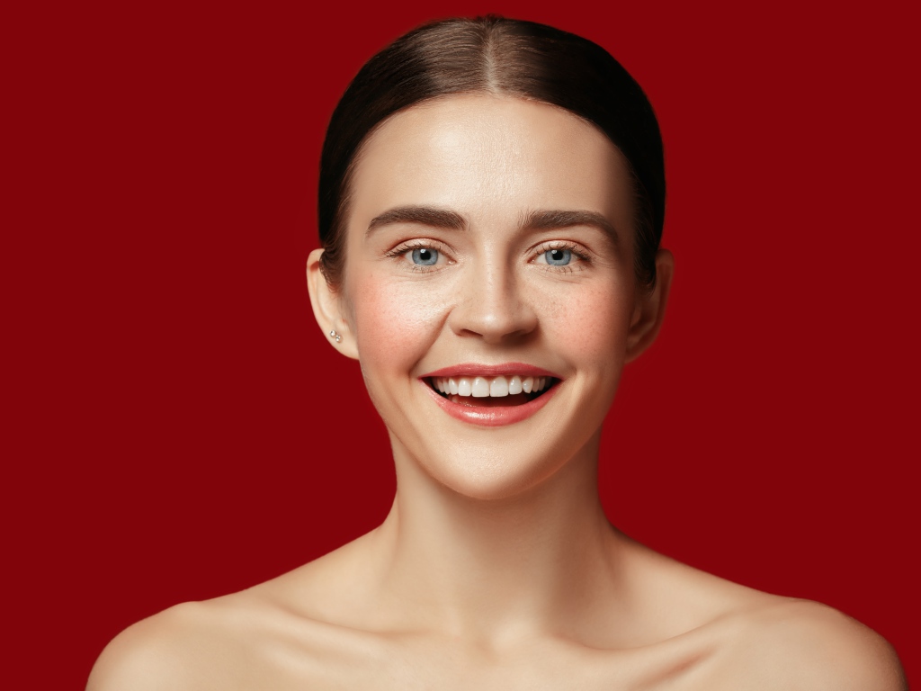 Улыбающаяся молодая девушка на красном фоне