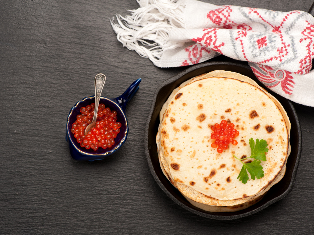 Тонкие блинчики с красной икрой на столе