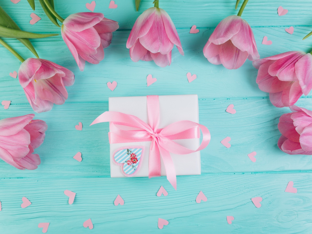 Розовые тюльпаны с подарком на голубом фоне на 8 марта