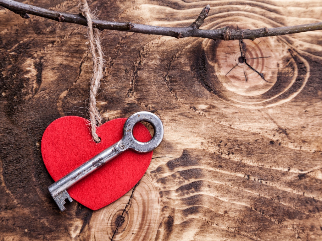 Красное сердечко и ключ на деревянном столе