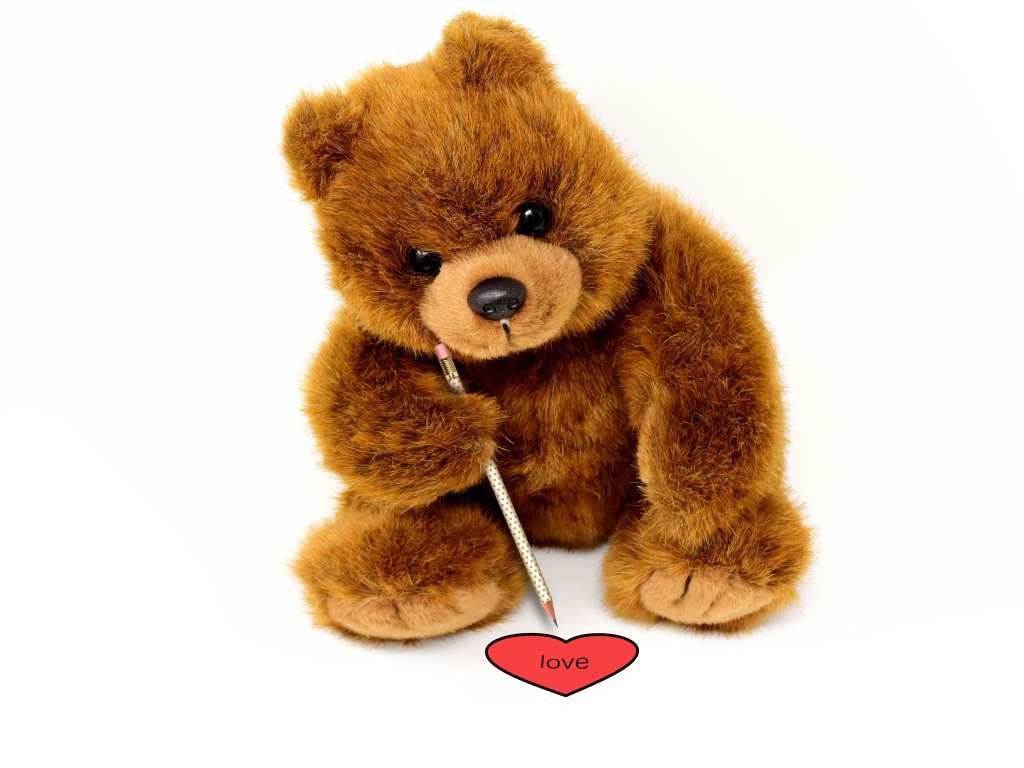 Игрушка медвежонок рисует сердце на белом фоне 