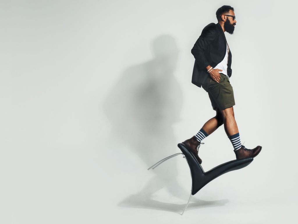 Мужчина балансирует на черном кресле