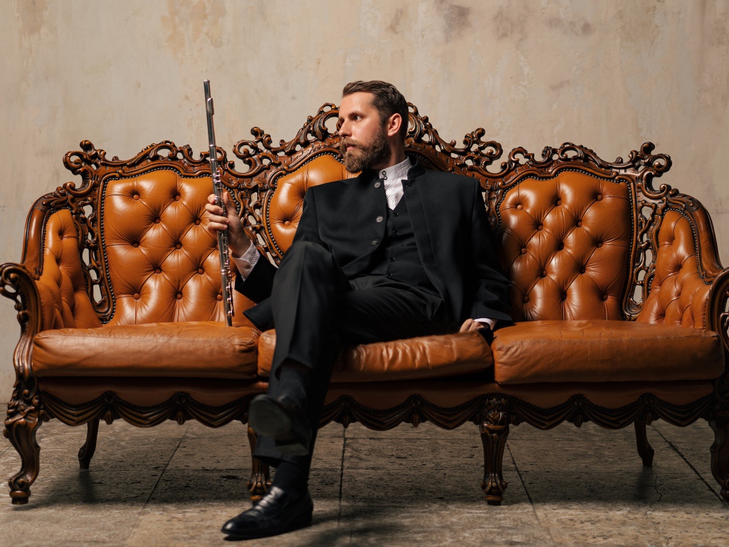 Солидный мужчина в костюме сидит на диване