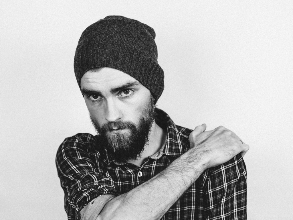 Бородатый мужчина в шапке на белом фоне 