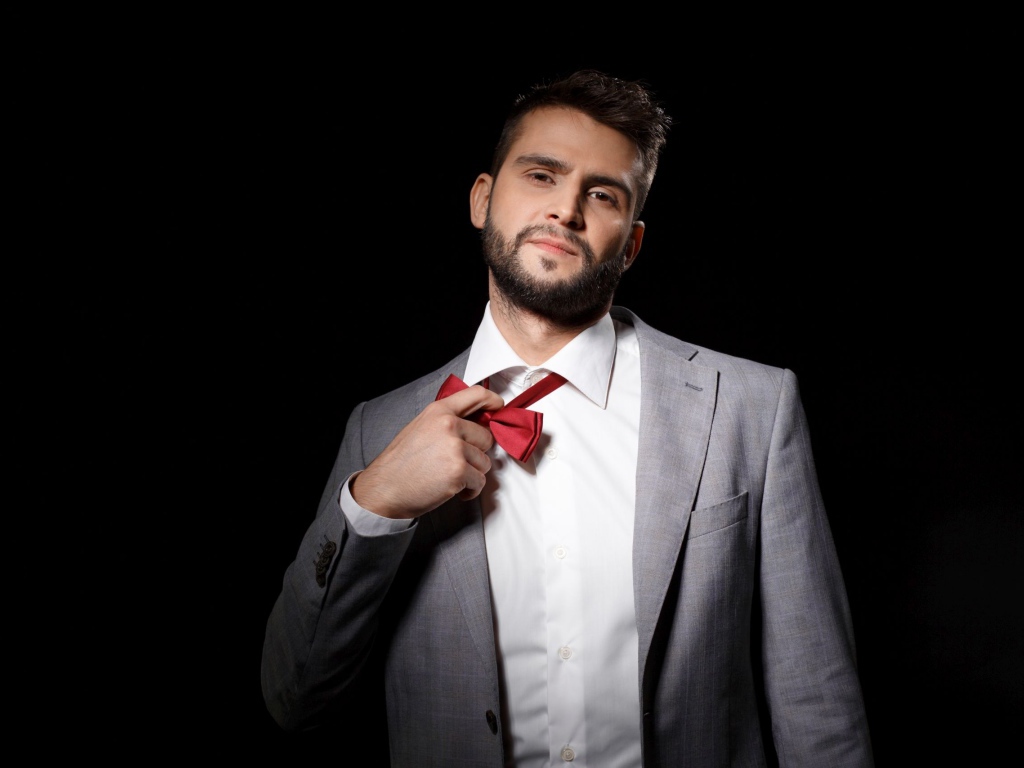 Красивый мужчина в сером пиджаке на черном фоне