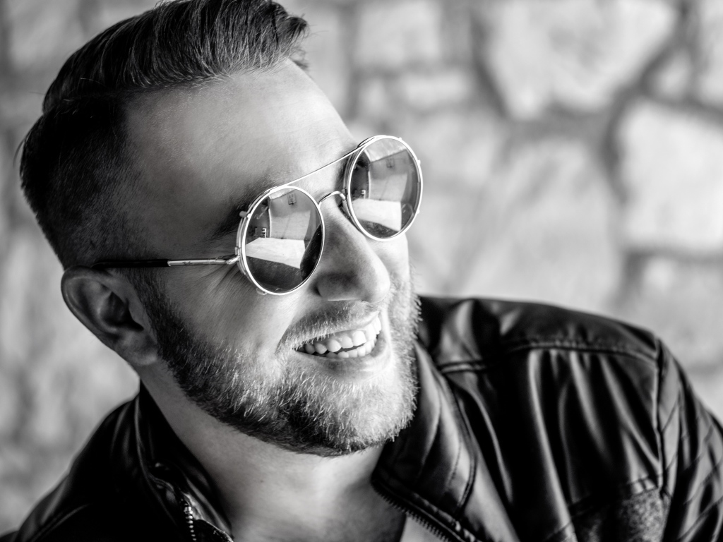 Улыбающийся брутальный мужчина в черных очках