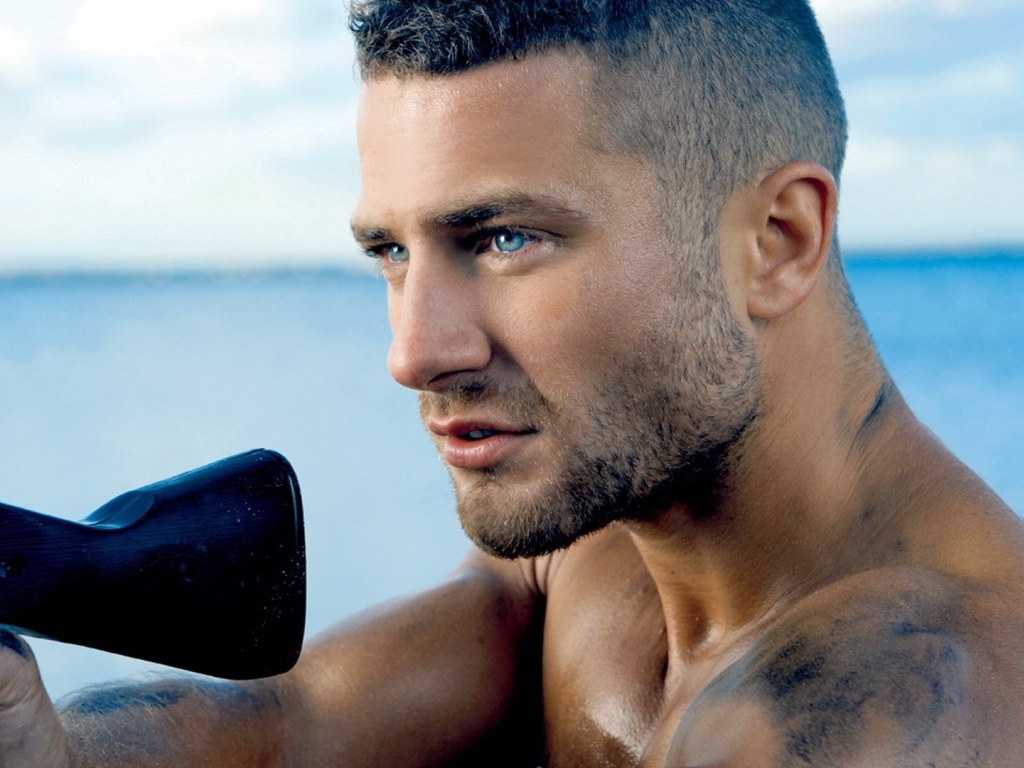 Сильный голубоглазый мужчина с винтовкой в руках 