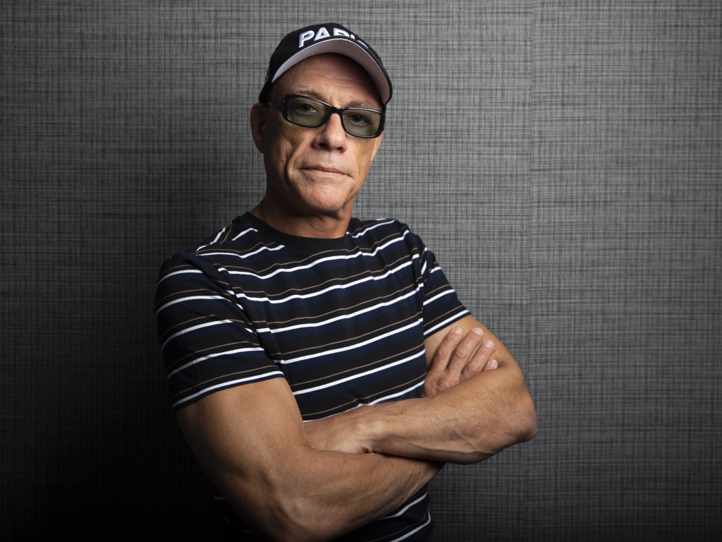 Популярный актер Жан-Клод Ван Дамм в кепке у стены